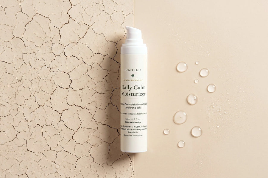 Dry cracked clay beside dewy water droplets, with the OMTILO Daily Calm Moisturizer