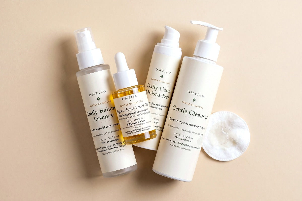 Several OMTILO skincare bottles crowded together with a used cotton pad