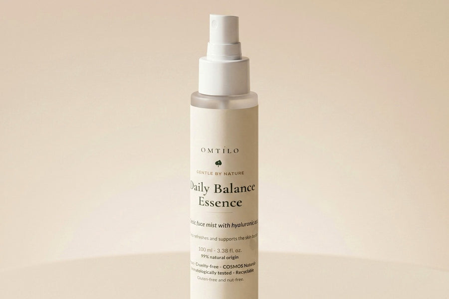 The OMTILO Daily Balance Essence mist on a warm beige surface