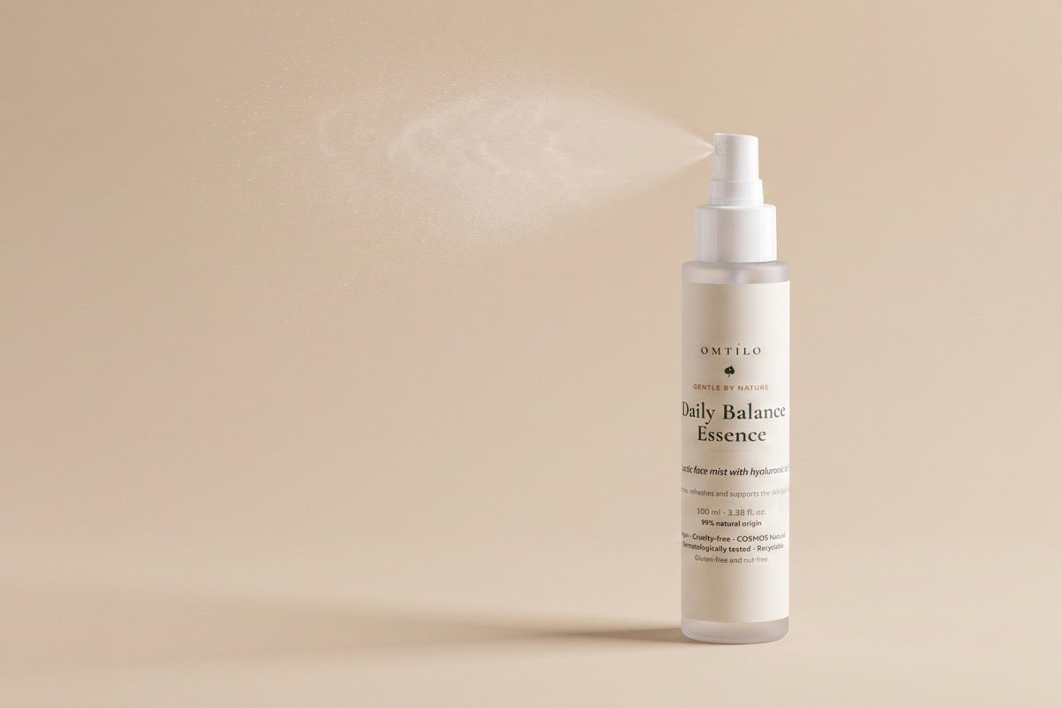 The OMTILO Daily Balance Essence with a fine hydrating mist on a warm beige background