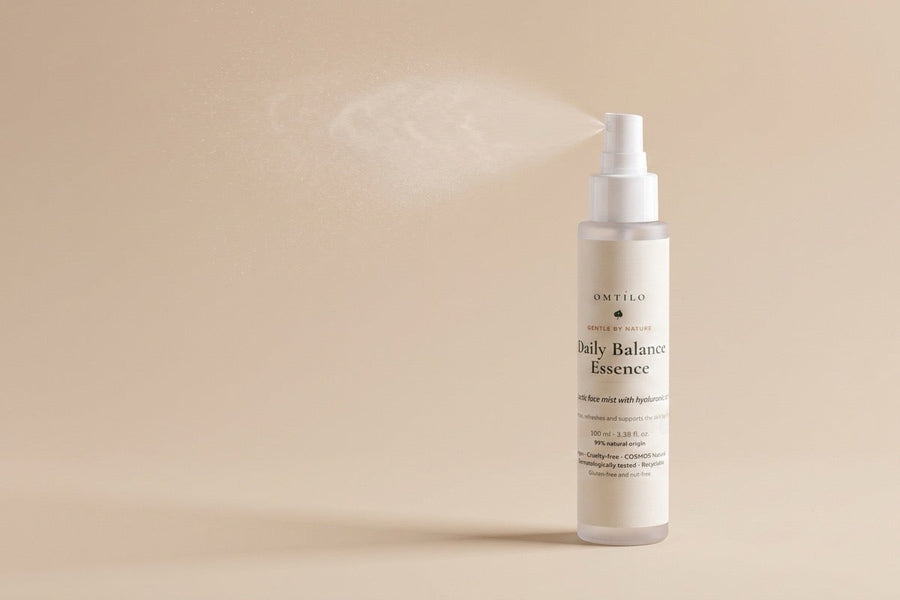 The OMTILO Daily Balance Essence with a fine hydrating mist on a warm beige background