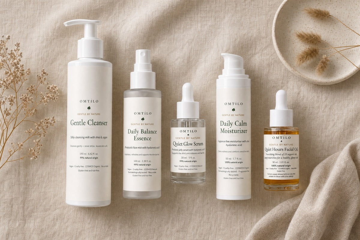 OMTILO skincare products laid out on linen showing the routine order, on a warm beige background